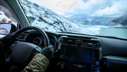 Driving off road car on snowing high altitude mountain trail on winter day
