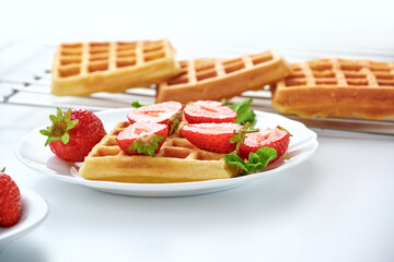 Breakfast with freashly baked belgian waffles on white background copy space.