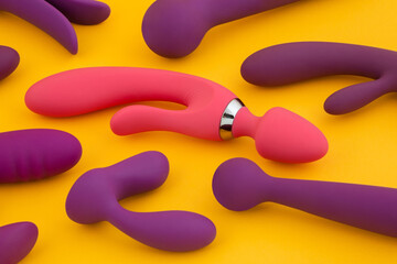 Erotic pleasure toys on a yellow background. Sex gadgets and masturbation devices. Rubber and...