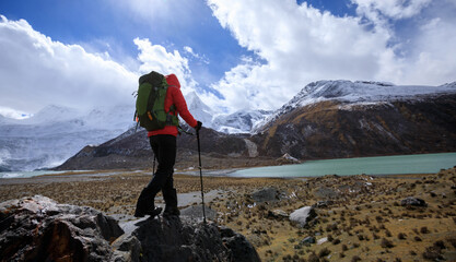 Woman backpacker hiking in winter high altitude mountains