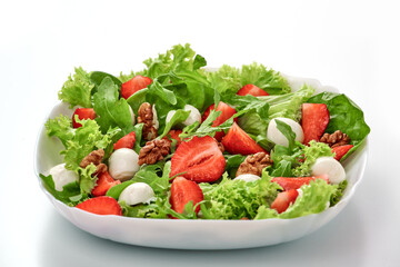 Healthy salad with arugula, lettuce leaves, spinach, mozzarella, strawberry and walnut