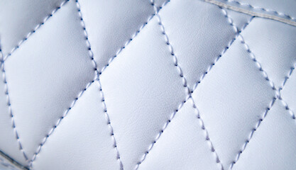 Close-up of synthetic fabric with white diamond stitching. Texture the diamond in a classic style....