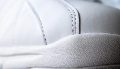 Close up low angle view of the outsole of the front of the new white sneakers. Rubber sole on the...