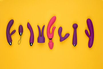Erotic pleasure toys on a yellow background. Sex gadgets and masturbation devices. Rubber and...