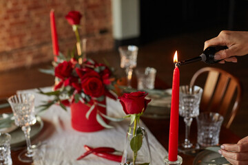 Unusual decoration of a wedding table with red roses, eucalyptus in red boxes with red candles and chili peppers in a dark interior