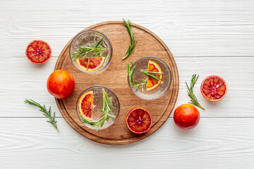 Glasses of cold drink with red oranges and rosemary