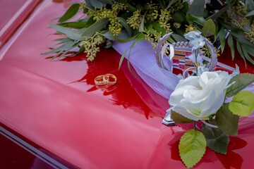 Wedding bouquet and rings on an American car.