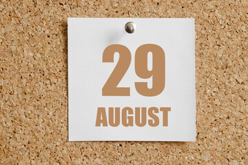 august 29. 29th day of the month, calendar date.White calendar sheet attached to brown cork board.Summer month, day of the year concept