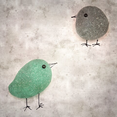 stylish textured old paper background with funny little penguins made of sea glass pebble pieces 