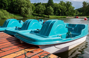Blue catamarans are moored on the lake. Summer, sunny day
