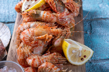 Greenlad shrimp cooking and served on a wooden board.