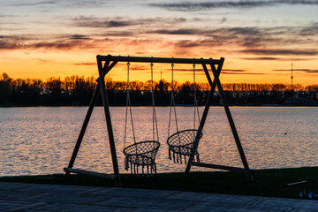 swings in front of sunset alphen aan den rijn water lake