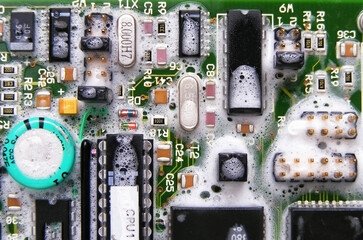 Circuit board with electronics in soap and water isolated on white background
