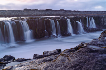 Obraz premium A magnificent view of the numerous streams of waterfalls flowing down to the river at the Dettifoss, Iceland
