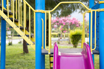 Yellow, purple and blue slide in the playground against the beautiful nature background