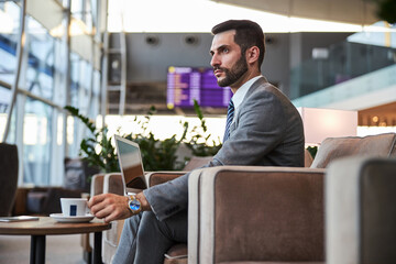 Thoughtful attractive businessman with cup of coffee