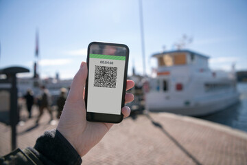 Hand holding smartphone with QR code on screen