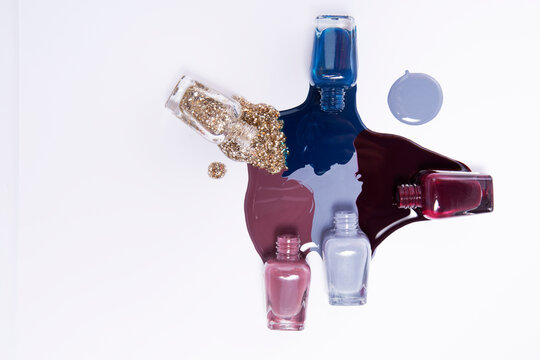 Multicolored nail polish spilling from bottles