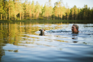 Woman with dog swimming in lake