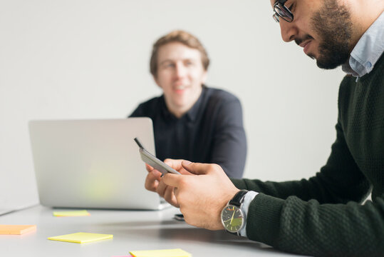 Man using cell phone during meeting