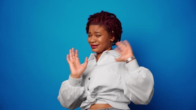Dissatisfied afro american woman showing her refusal, denies something against blue background