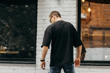 Man wearing black blank t-shirt with space for your logo or design. Mock up