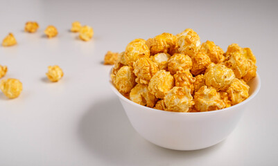 Popcorn with caramel flavor in a white plate on a white background