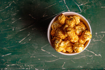 popcorn in a paper cup on a green background