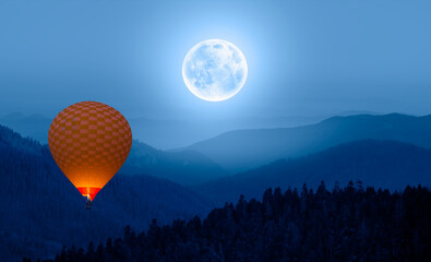 Beautiful landscape with blue misty silhouettes of mountains with full moon Hot air balloon in the foreground "Elements of this image furnished by NASA"