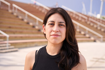 Outdoor portrait of a Latina woman looking at the camera with a serious face. Close up of a human...