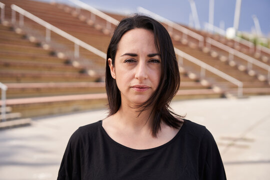 Outdoor portrait of a Hispanic woman looking at the camera with a serious face. Close-up of a serious female face. Concept of people and emotions.