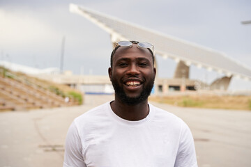 Outdoor portrait of an African-American man looking at the camera smiling. Close-up of a cheerful male face. Concept of equality. Black lives matter.