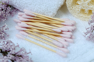 Fototapeta na wymiar Bamboo cotton swabs in bathroom. Eco-friendly pink buds.