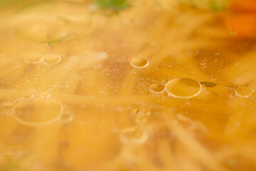 Close up macro shot of the chicken soup with macaroni. 