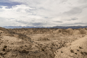 dried sand dunes against the backdrop of mountains