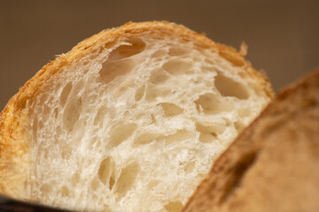 Loaf of white bread with brown bread in the foreground. 