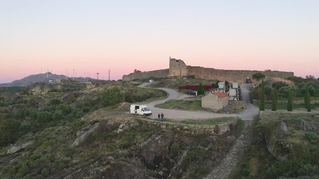 Couple with a camper van drone aerial view of Sortelha historic village with castle in the mountains, Portugal