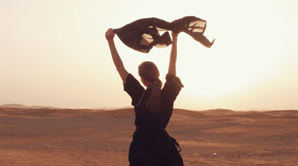 Portrait of a young Arab woman wearing traditional black clothing during beautiful sunset over the...