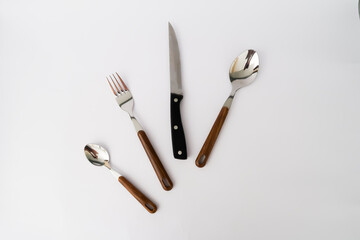 set cutlery of spoon, fork, and knife with a wood vintage handle on the white background.