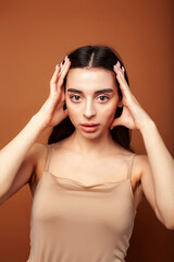 Obraz premium cute happy young indian woman posing cheerful on brown background in studio close up smiling, fashion beauty