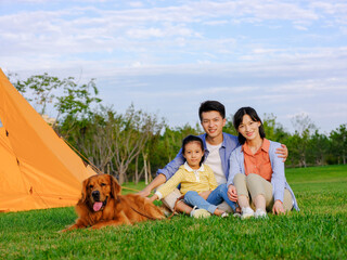 Fototapeta premium Happy family of three and pet dog in the park
