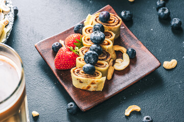 Breakfast pancake. A healthy breakfast with fruit. Pancake with fruit. Iced coffee and fruit. Dark background with pancakes and fruit.