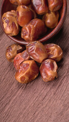 Dates in wooden bowl on background. dried dates fruit.