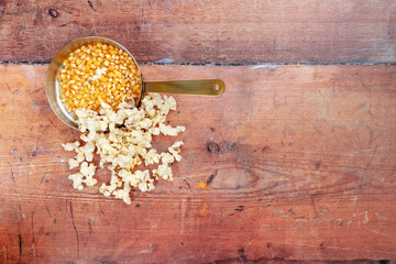 Popcorn shot from above in a copper saucepan on a wooden background with space for text