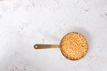 Popcorn shot from above in a copper saucepan on a wooden background with space for text