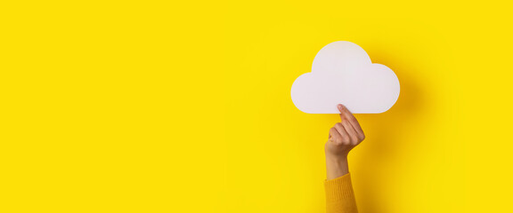 cloud in hand over yellow background, storage concept, panoramic layout - obrazy, fototapety, plakaty