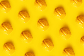 toy worker's helmet pattern over yellow background, construction concept