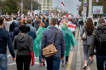 There is a rally for the change of power, where many people pass along the street with lanterns on...
