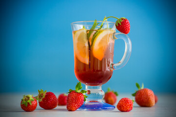 refreshing cool strawberry lemonade with lemon, ice and mint in a glass