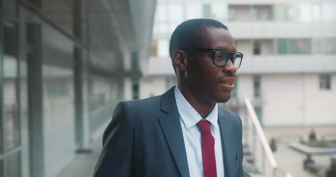 Confident young afro-american businessman standing outside office building